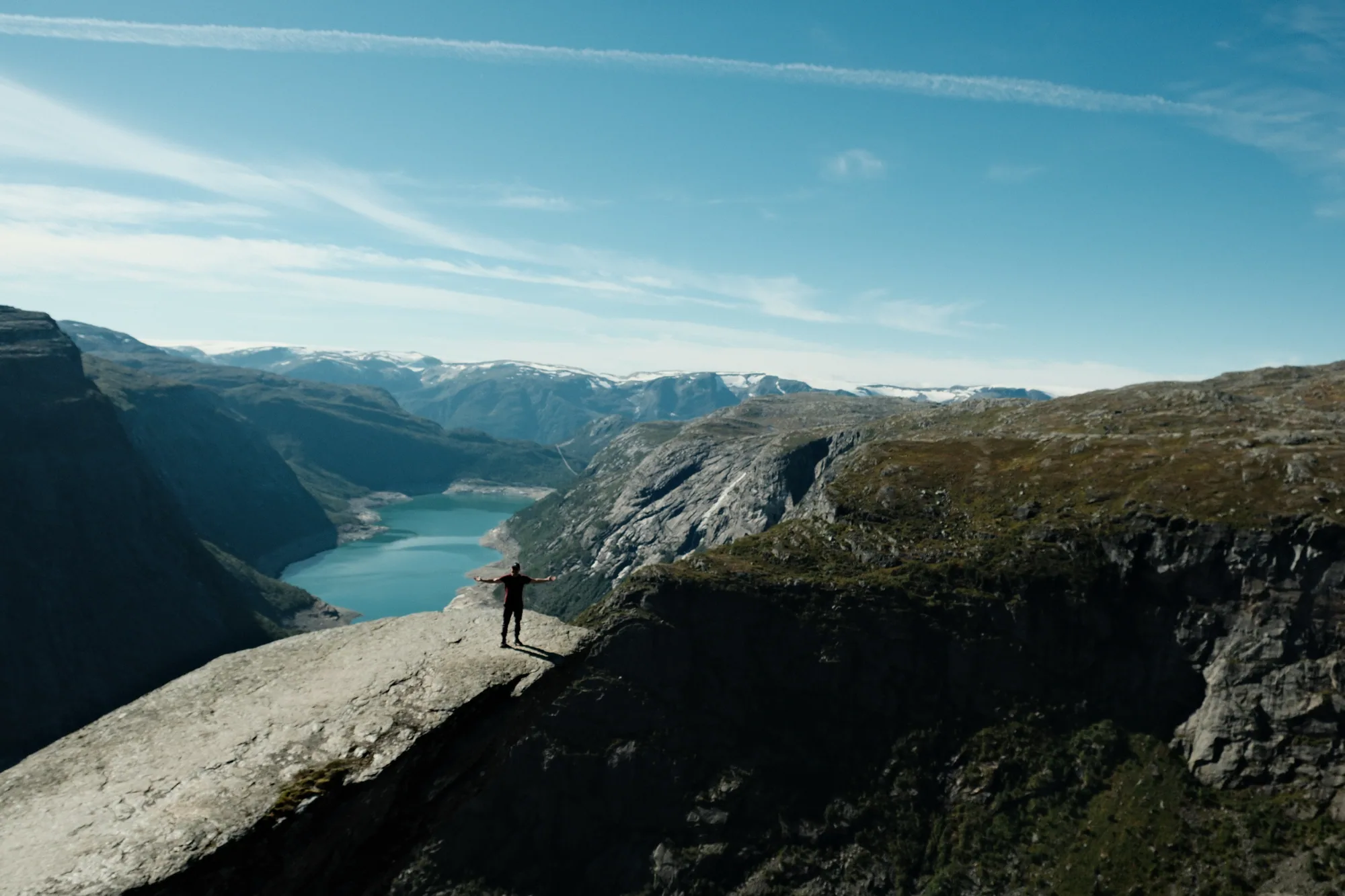 Andrey standing in the distance above a mountain lake